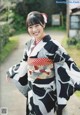 A woman in a black and white kimono posing for a picture.