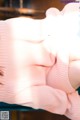 A woman in a pink sweater holding a bottle of water.