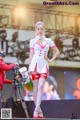 A woman in a white and red outfit holding a water bottle.