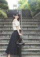 A woman standing on a set of stairs with a cane.