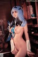 A naked woman with blue hair standing in front of a book shelf.