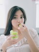 A woman holding a glass of green grapes in her hand.