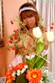 A woman in a pink dress holding a bouquet of flowers.