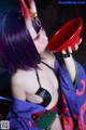A woman in a purple and red outfit holding a red cup.